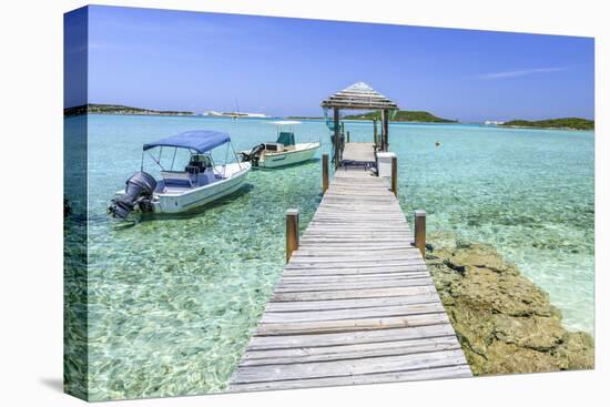 A Wood Pier Leads to Moored Boats and Clear Tropical Waters Near Staniel Cay, Exuma, Bahamas-James White-Stretched Canvas