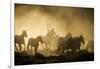 A wrangler herding horses through backlit dust cloud in golden light of sunrise-Sheila Haddad-Framed Photographic Print