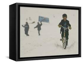 A Young Afghan Boy Rides His Bicycle on a Snow Covered Street-null-Framed Stretched Canvas