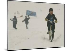 A Young Afghan Boy Rides His Bicycle on a Snow Covered Street-null-Mounted Photographic Print