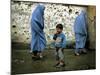 A Young Afghan Refugee Boy Stands in a Pair of Adult's Shoes-null-Mounted Photographic Print