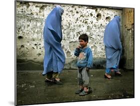 A Young Afghan Refugee Boy Stands in a Pair of Adult's Shoes-null-Mounted Photographic Print