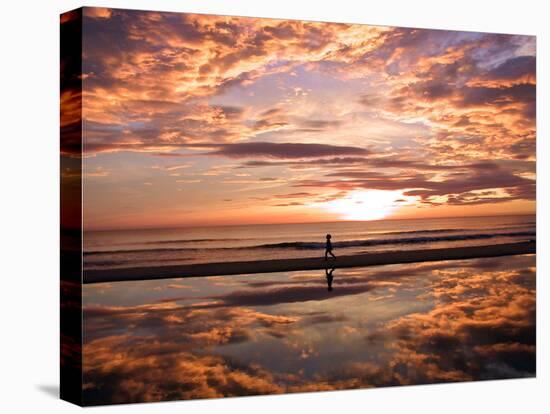 A Young Boy Takes an Early Morning Jog as the Sun Rises Along China Beach-null-Stretched Canvas