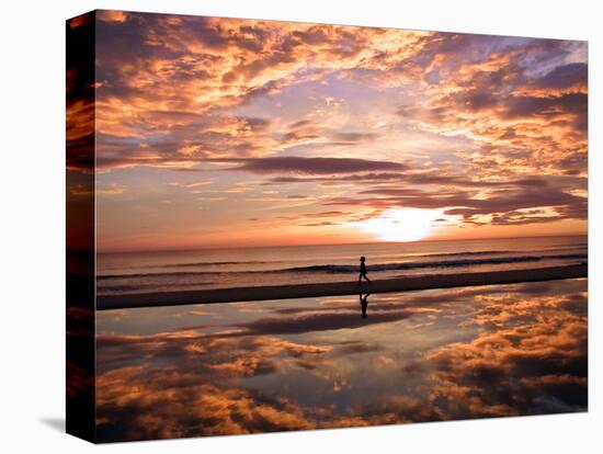 A Young Boy Takes an Early Morning Jog as the Sun Rises Along China Beach-null-Stretched Canvas