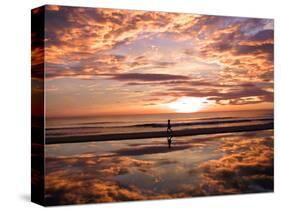 A Young Boy Takes an Early Morning Jog as the Sun Rises Along China Beach-null-Stretched Canvas