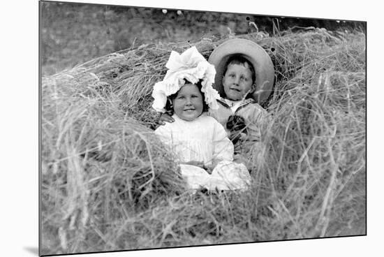 A Young Brother and Sister Nestled in the Hay, Ca. 1900-null-Mounted Photographic Print