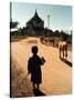 A Young Burmese Boy Tends His Family's Cows Near the Thatbinnyu Temple-null-Stretched Canvas