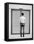 A Young Man Standing in the Street Looking at a Pair of Doors-India Hobson-Framed Stretched Canvas