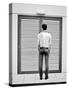 A Young Man Standing in the Street Looking at a Pair of Doors-India Hobson-Stretched Canvas