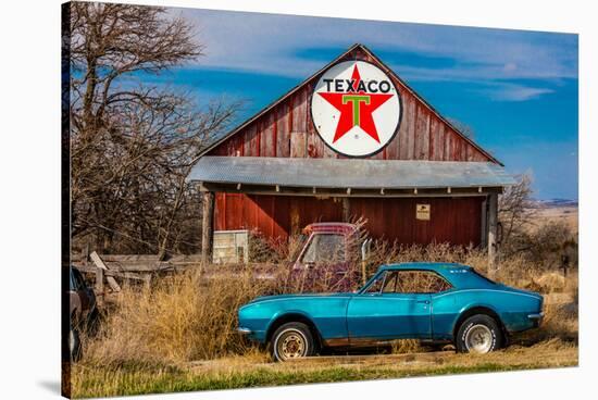 Abandoned blue Camaro Chevrolete in front of deserted Texaco Station, remote part of Nebraska-null-Stretched Canvas