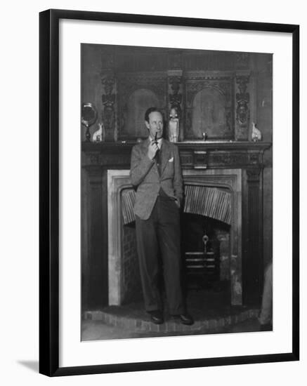 Actor Leslie Howard Smoking Pipe as He Stands by His Fireplace, at Home in Dorking, England-null-Framed Premium Photographic Print