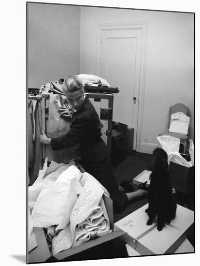 Actress Grace Kelly Packing for Wedding to Prince Rainer of Monaco While Pet Poodle Looks On-Lisa Larsen-Mounted Premium Photographic Print