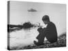 Actress Mia Farrow Pensively Sitting on Rocky Shore of Lake Geneva as Passenger Boat Passes By-Bill Eppridge-Stretched Canvas