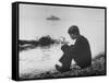 Actress Mia Farrow Pensively Sitting on Rocky Shore of Lake Geneva as Passenger Boat Passes By-Bill Eppridge-Framed Stretched Canvas