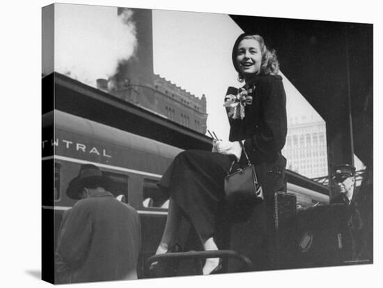 Actress Patricia Neal Sitting on Her Luggage on the Platform of a Train Station During a Stopover-Ed Clark-Stretched Canvas