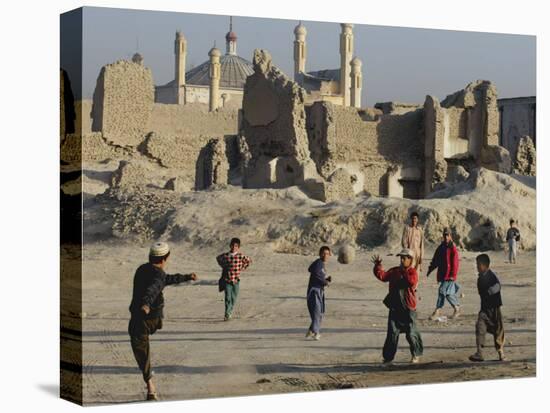 Afghan Boys Play Soccer Near a Mosque and Ruined Buildings During the Early Morning-null-Stretched Canvas
