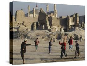 Afghan Boys Play Soccer Near a Mosque and Ruined Buildings During the Early Morning-null-Stretched Canvas