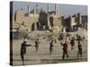 Afghan Boys Play Soccer Near a Mosque and Ruined Buildings During the Early Morning-null-Stretched Canvas