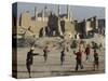 Afghan Boys Play Soccer Near a Mosque and Ruined Buildings During the Early Morning-null-Stretched Canvas