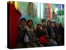 Afghan Boys Watch a Movie on a Television, Unseen, as They Eat Ice Cream at an Ice Cream Shop-Rodrigo Abd-Stretched Canvas