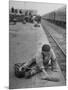 Aged Refugee Fighting Hunger, Sweeps Up Spilled Rice on the Railroad Station Platform-Jack Birns-Mounted Photographic Print