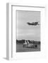 Airplane Flying over Race Car in Action-null-Framed Photographic Print