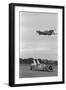 Airplane Flying over Race Car in Action-null-Framed Photographic Print