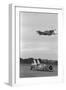 Airplane Flying over Race Car in Action-null-Framed Photographic Print