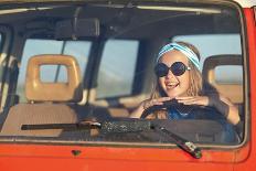A Beautiful Teenage Girl in Sunglasses and a Blue T-Shirt Sits behind the Wheel and Enjoys the Jour-Akimicheva Olga-Framed Photographic Print