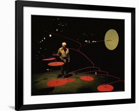 Alexander Calder Walking Past Exhibit of His Mobiles at the Guggenheim Museum-Gjon Mili-Framed Premium Photographic Print