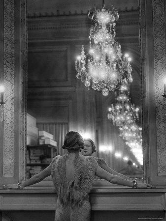 Model in Ostrich Feather Trimmed Gown Pausing to Regard Herself in Grand Mirror of Molyneux Atelier