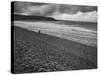 Along British Coastline, Woman Walking on Pebbled Shore-Nat Farbman-Stretched Canvas