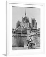 American Travelers Below France's Medieval Abbey at Mont Saint Michel Reading Together from a Book-Yale Joel-Framed Photographic Print