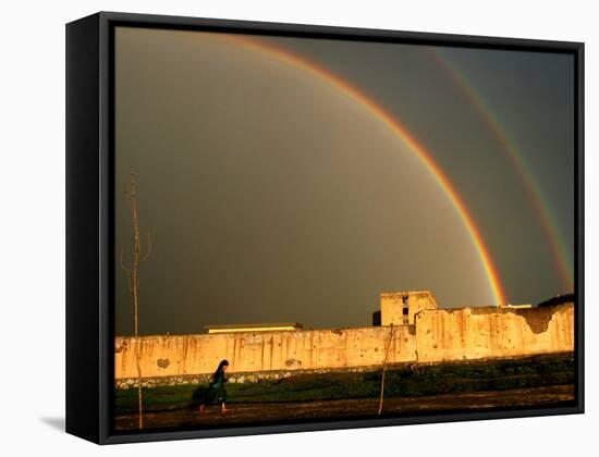 An Afghan Girl Walks Past Destroyed Buildings Occupied by Refugees-null-Framed Stretched Canvas