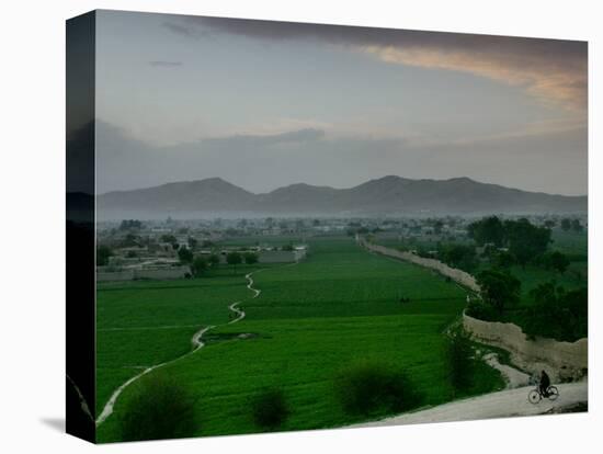 An Afghan Man Rides His Bicycle on a Dirt Road on the Northern Edge of Kabul, Afghanistan-David Guttenfelder-Stretched Canvas