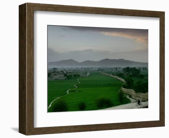 An Afghan Man Rides His Bicycle on a Dirt Road on the Northern Edge of Kabul, Afghanistan-David Guttenfelder-Framed Photographic Print