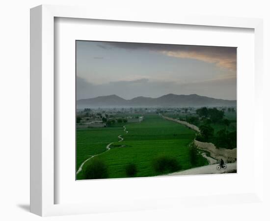 An Afghan Man Rides His Bicycle on a Dirt Road on the Northern Edge of Kabul, Afghanistan-David Guttenfelder-Framed Photographic Print