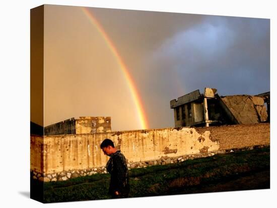 An Afghan Man Walks Past Destroyed Buildings Occupied by Refugees after a Heavy Rain-null-Stretched Canvas