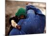 An Afghan Woman Holding Her Child Throws Back Her Burqa to See Her Way Along a Muddy Alley-null-Mounted Photographic Print