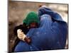 An Afghan Woman Holding Her Child Throws Back Her Burqa to See Her Way Along a Muddy Alley-null-Mounted Photographic Print