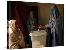 An Afghan Woman Wearing a Burqa Casts Her Ballot at a Polling Station-null-Stretched Canvas