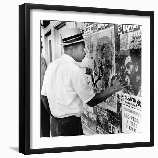 An African American Pokes His Finger into a Bullet Hole in the Oakland Black Panther's Headquarters-null-Framed Photo