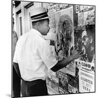 An African American Pokes His Finger into a Bullet Hole in the Oakland Black Panther's Headquarters-null-Mounted Photo