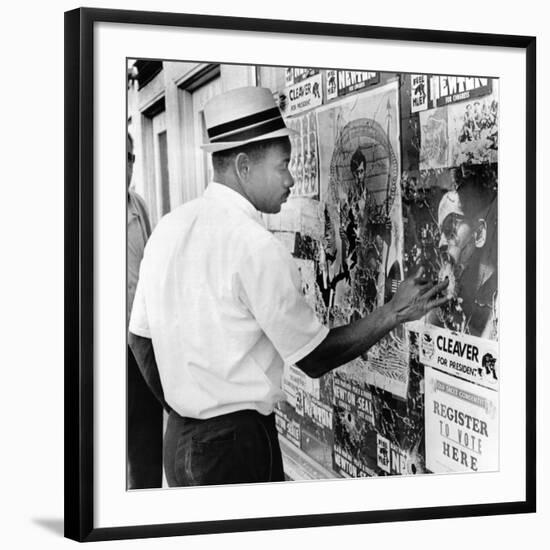 An African American Pokes His Finger into a Bullet Hole in the Oakland Black Panther's Headquarters-null-Framed Photo