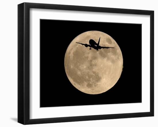 An Airliner is Silhouetted against a Full Moon-null-Framed Premium Photographic Print