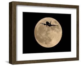 An Airliner is Silhouetted against a Full Moon-null-Framed Photographic Print