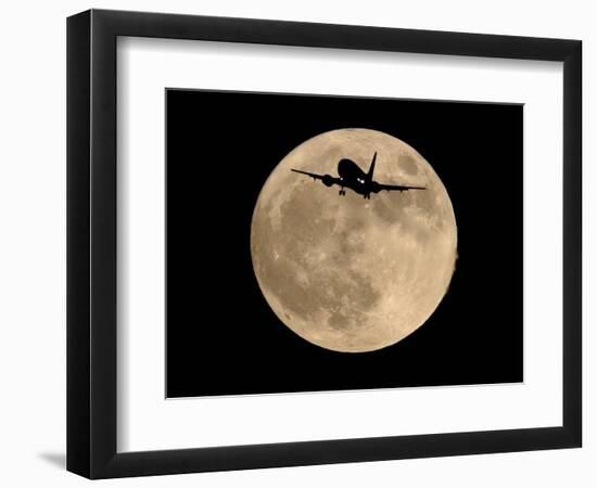 An Airliner is Silhouetted against a Full Moon-null-Framed Photographic Print