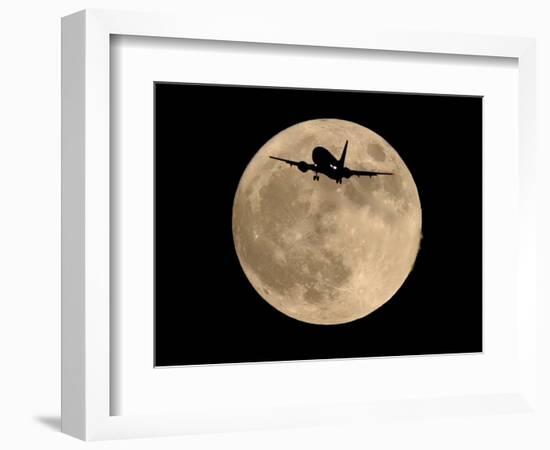 An Airliner is Silhouetted against a Full Moon-null-Framed Photographic Print