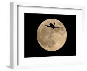 An Airliner is Silhouetted against a Full Moon-null-Framed Photographic Print