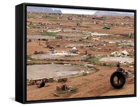 An Albanian Resident of Kukes Scavenges a Leftover Tractor Tire from a Vacant Refugee Camp-null-Framed Stretched Canvas